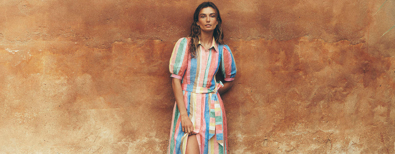 Woman standing in front of a wall wearing a Alexa Linen Maxi Shirt Dress