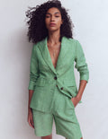Woman wearing a green suit against a white background