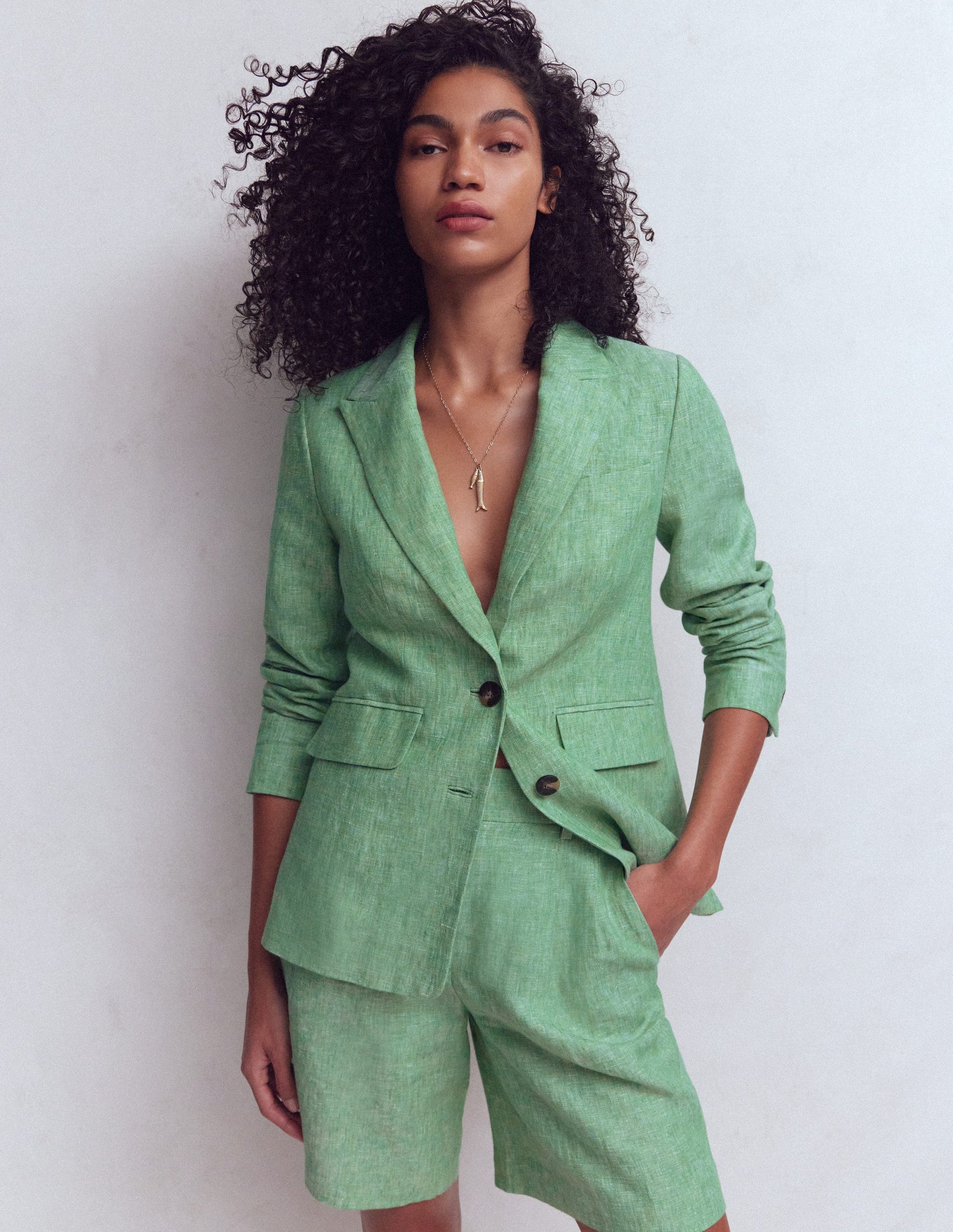 Woman wearing a green suit against a white background
