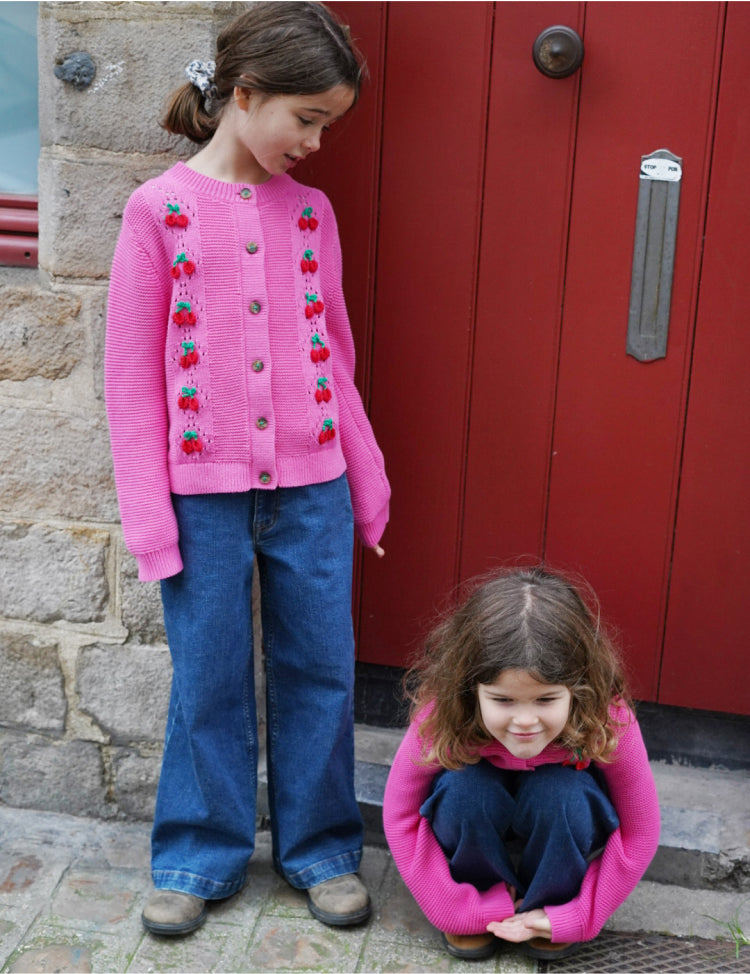 two Girls wearing pink cardigans