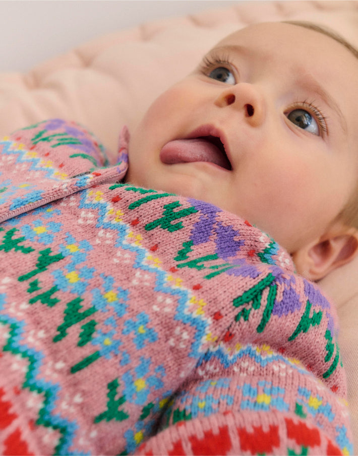 Baby laying down in Boden knitted cardigan