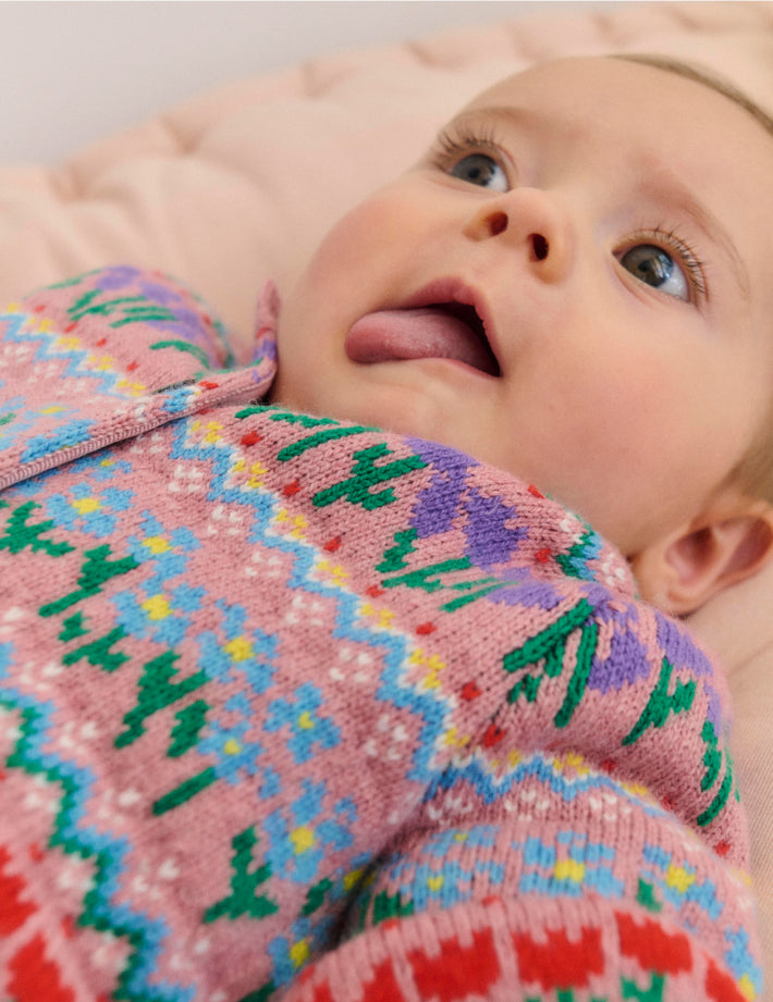 Baby laying down in Boden knitted cardigan