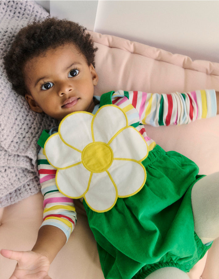 Baby facing the camera laying down wearing full boden outfit