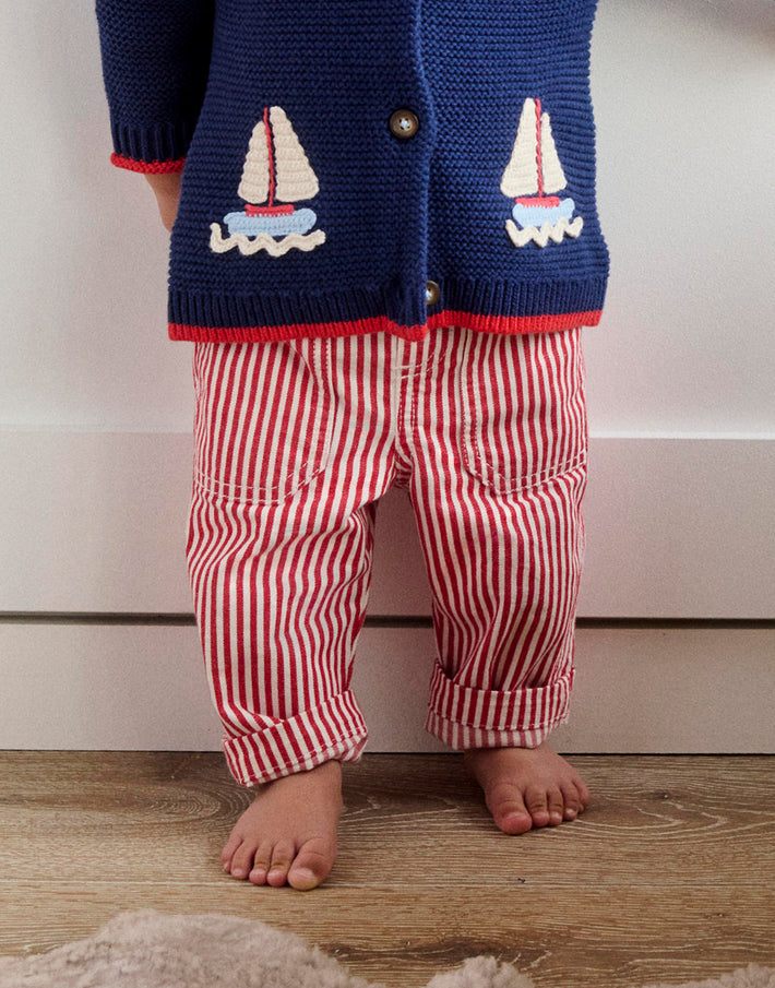 Photo of a baby from the shoulders down wearing knit cardigan and striped pants from Boden