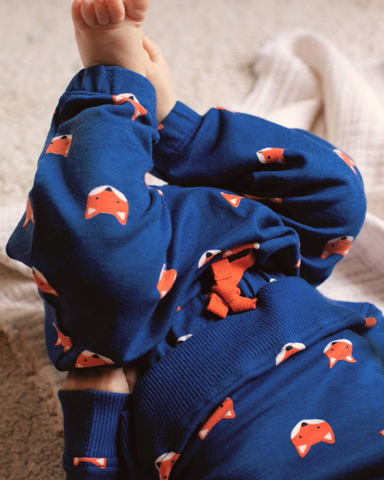 Blue pajama pants with fox pattern worn by a child on a light background