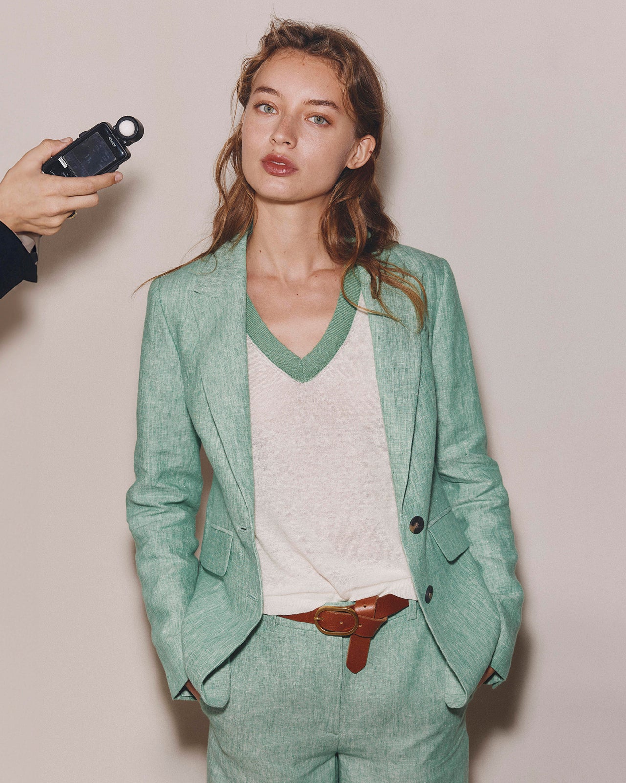 Woman wearing a green suit with a plain background