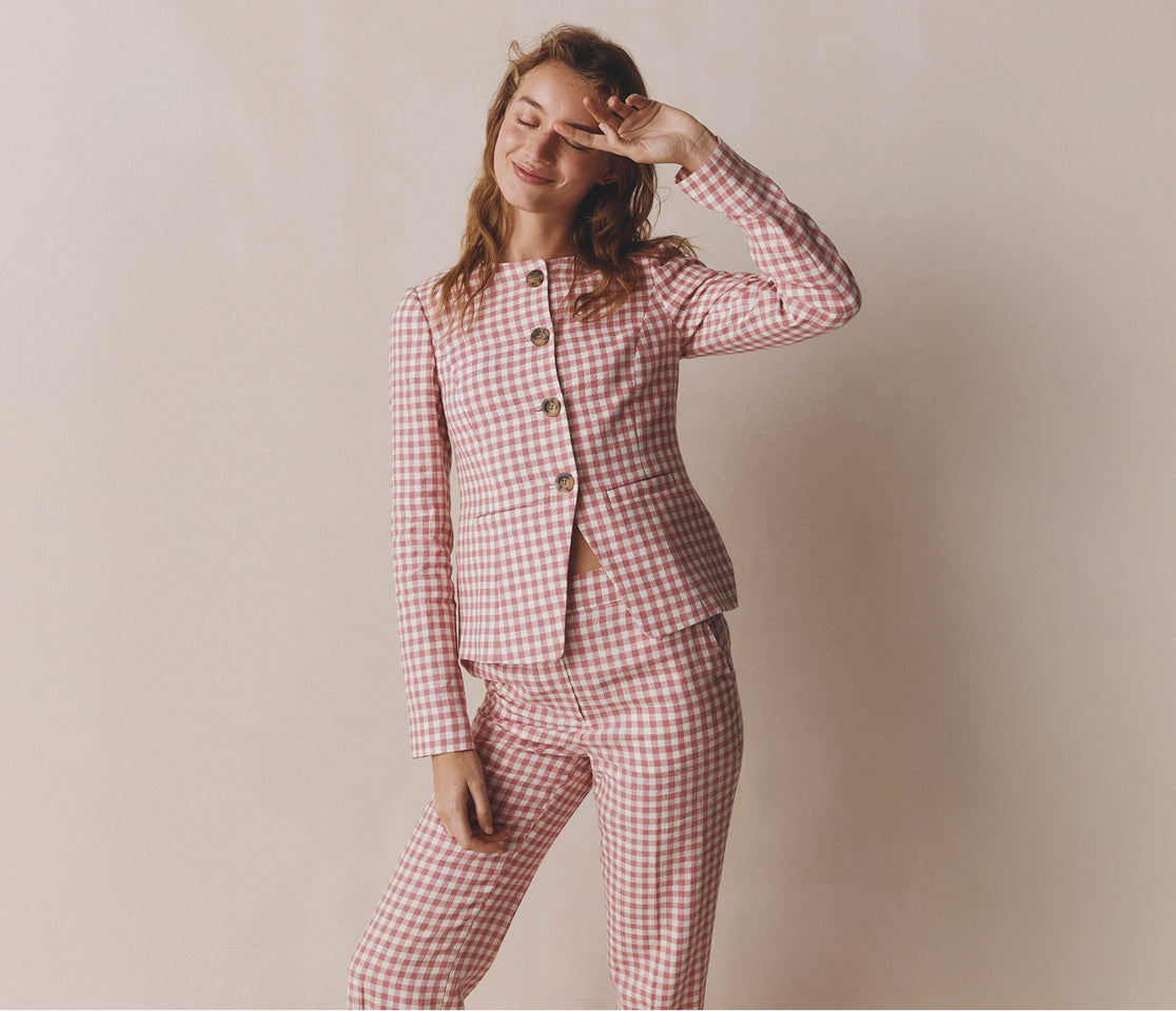 Woman wearing a red and white checkered outfit against a plain background