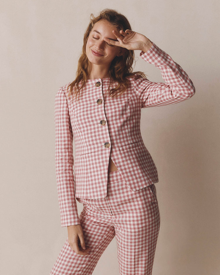 Woman wearing a red and white checkered outfit against a plain background