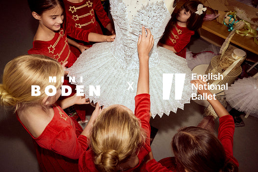 Children in red costumes interacting with a white ballet costume, featuring Minna Boden and English National Ballet logos.