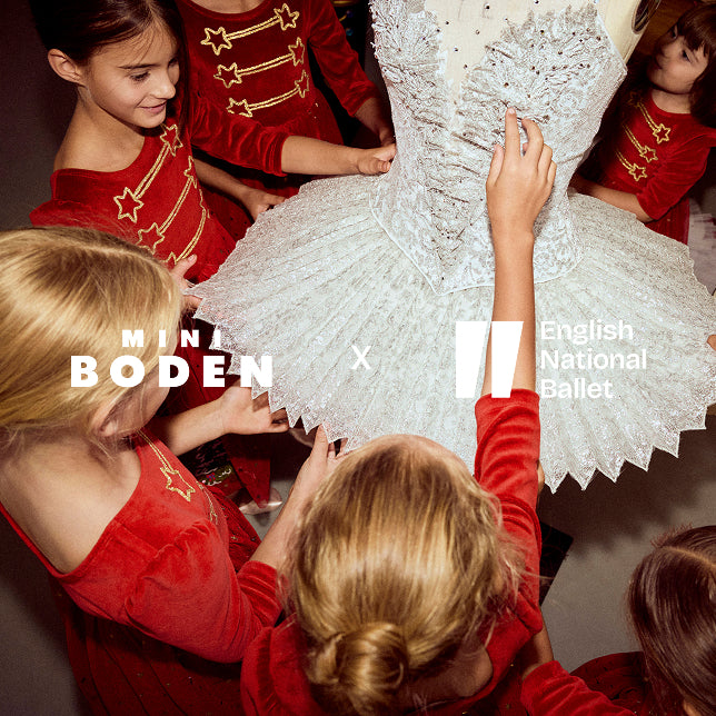 Children in red costumes interacting with a white ballet costume, featuring Minna Boden and English National Ballet logos.