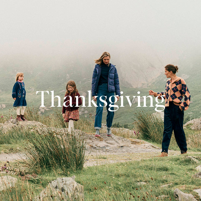 Family of four standing on a rocky path in a misty landscape with 'Thanksgiving' text overlay.