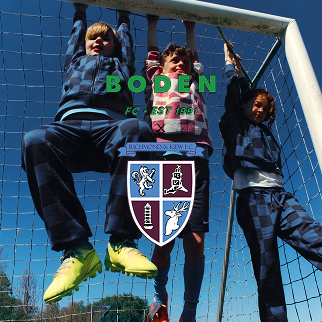 Three children playing on a soccer goal with 'Boden' branding.