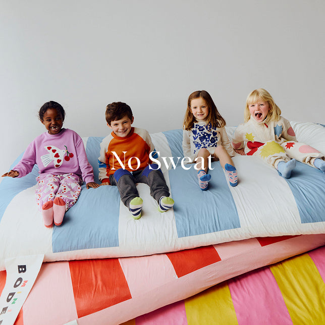 Four children sitting on a colorful bed with 'No Sweat' text overlay.
