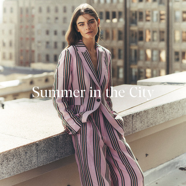 Woman in a striped outfit on a city rooftop with text 'Summer in the City'.