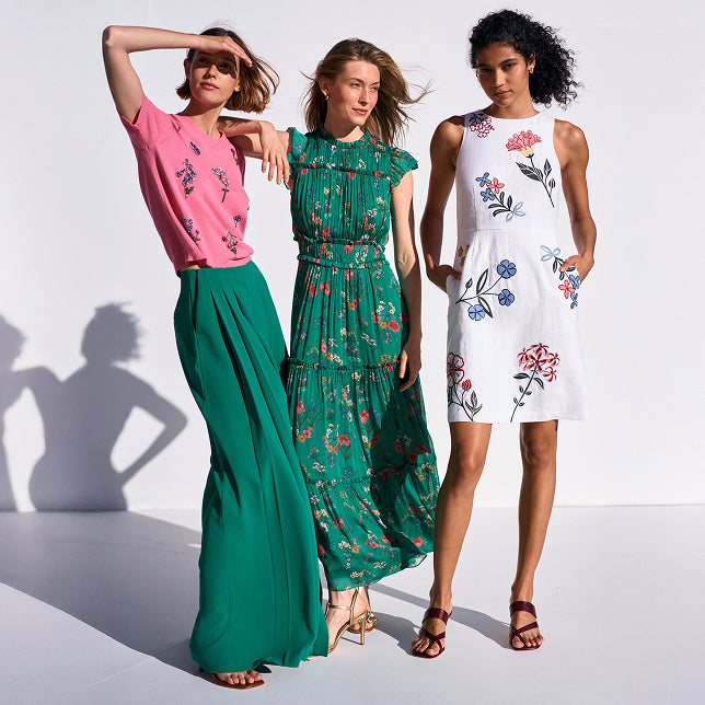 Three women wearing floral dresses on a white background