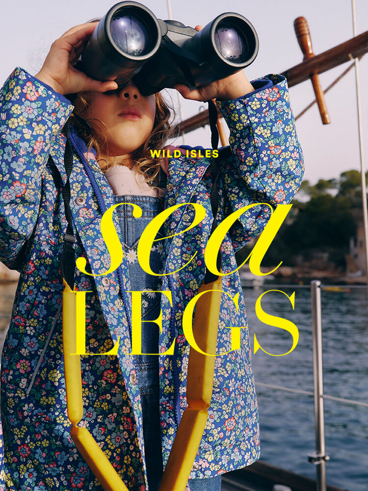 Two girls on a boat wearing matching Boden patterns, with the caption "Wild Isles: Sea Legs"