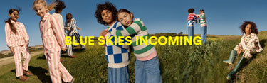 Children in colorful outfits standing on grass with 'Blue Skies Incoming' text overlay.