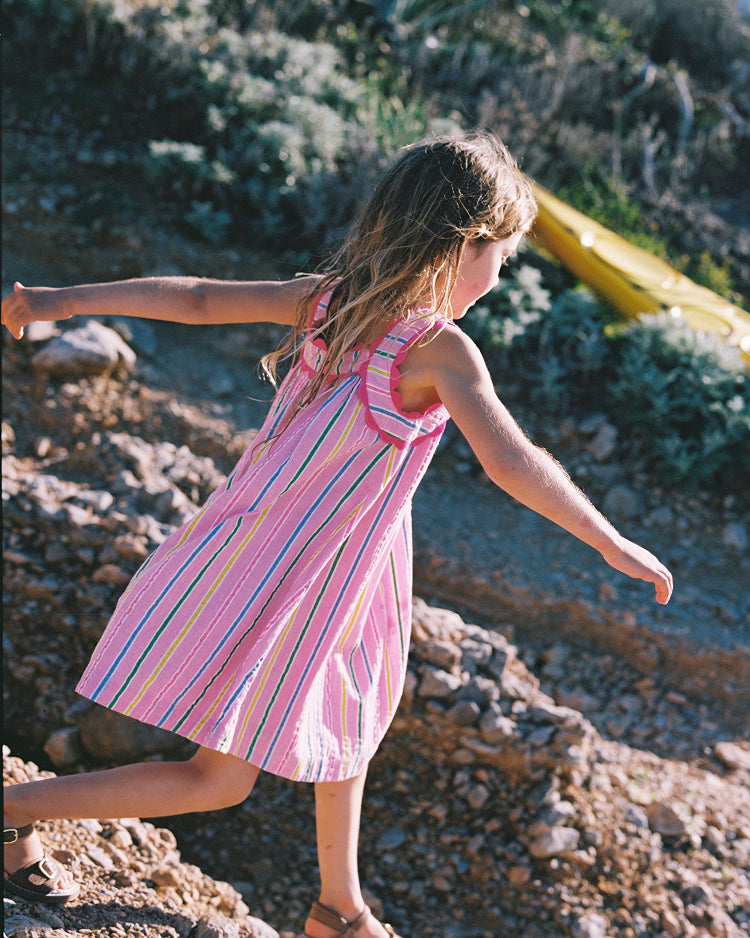 Girl wearing Boden pink and colourful stripe dress