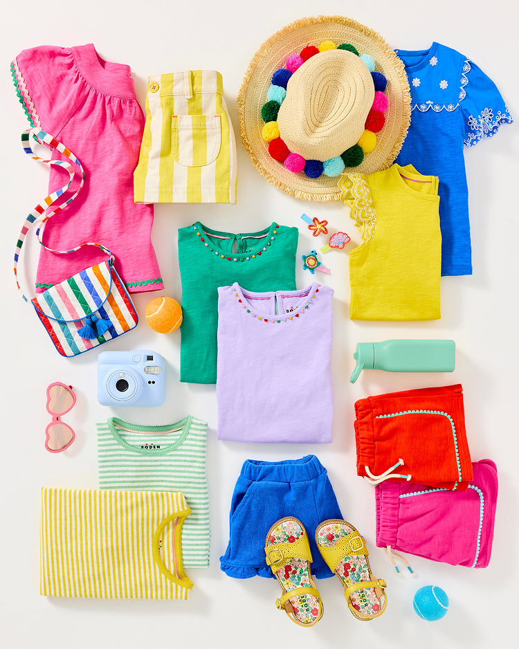 Colourful girl's Boden clothes folded and ready to be packed for summer camp
