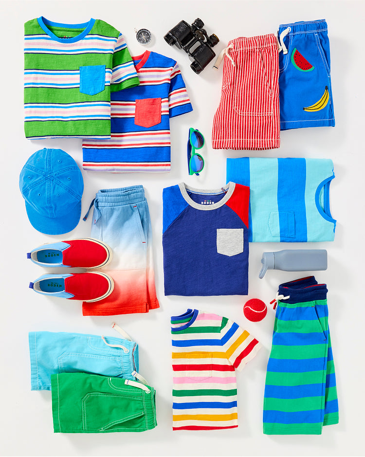 Colourful boy's Boden clothes folded and ready to be packed for summer camp