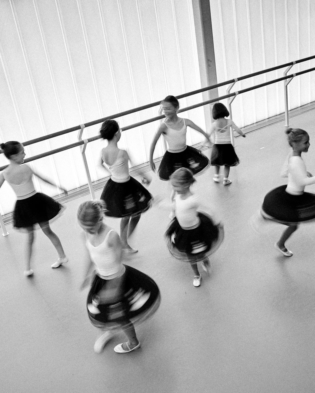 Black and white photo of young dancers practicing in a studio.