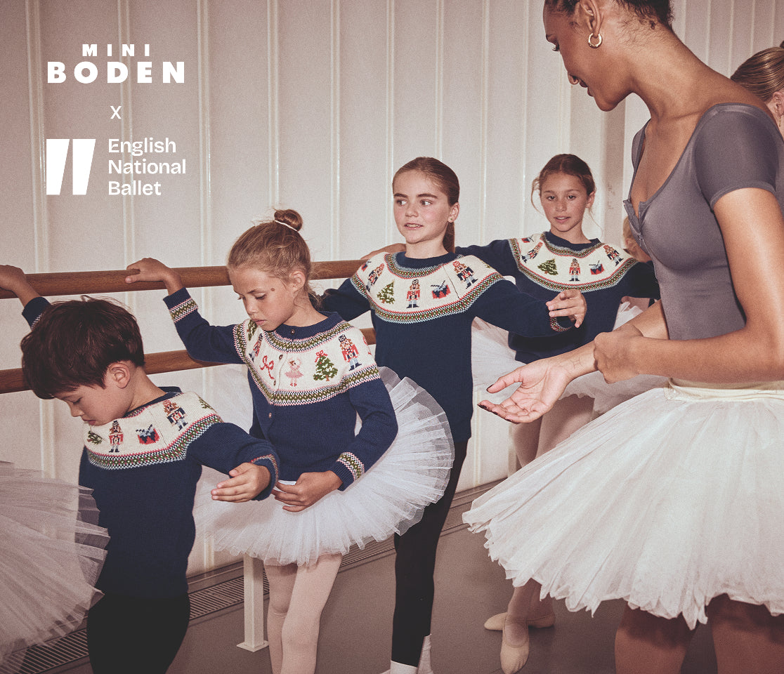 Children in ballet attire with a teacher at a barre, featuring Mini Boden and English National Ballet logos.