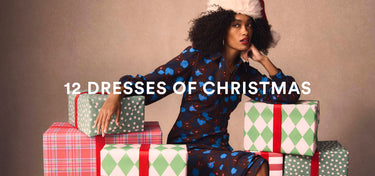 Woman in a patterned dress sitting on Christmas presents with text '12 Dresses of Christmas'.