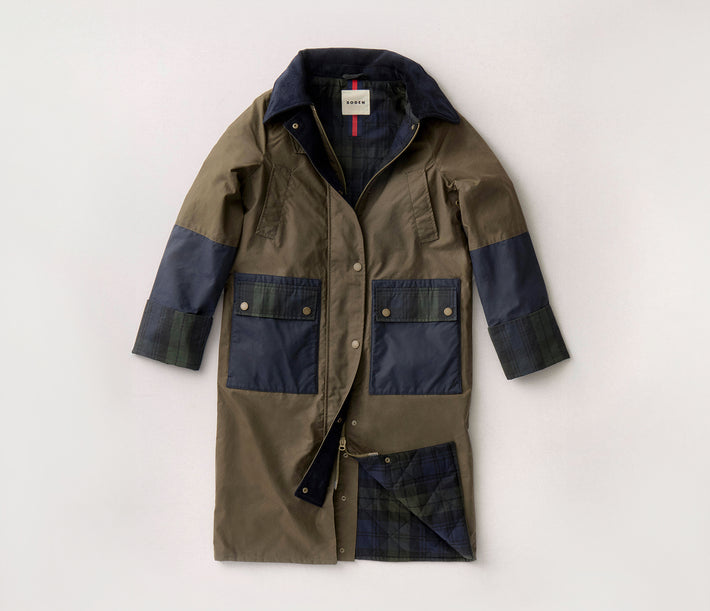 Green and navy coat with a visible brand label on a light gray background