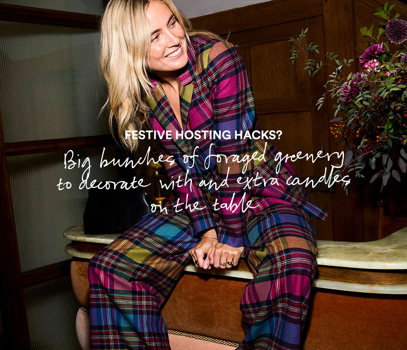 Person wearing a colorful plaid outfit sitting on a wooden bench with text about festive hosting hacks.