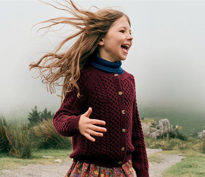 Young girl running outdoors with a blurred natural background
