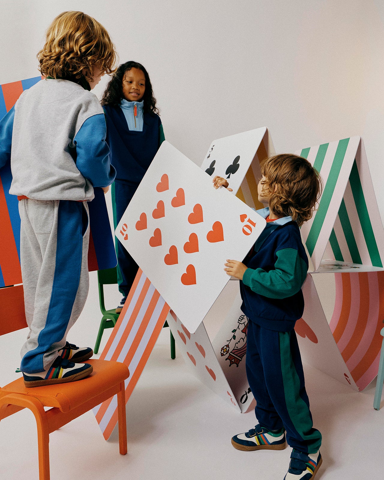 Children playing with oversized card props in a studio setting