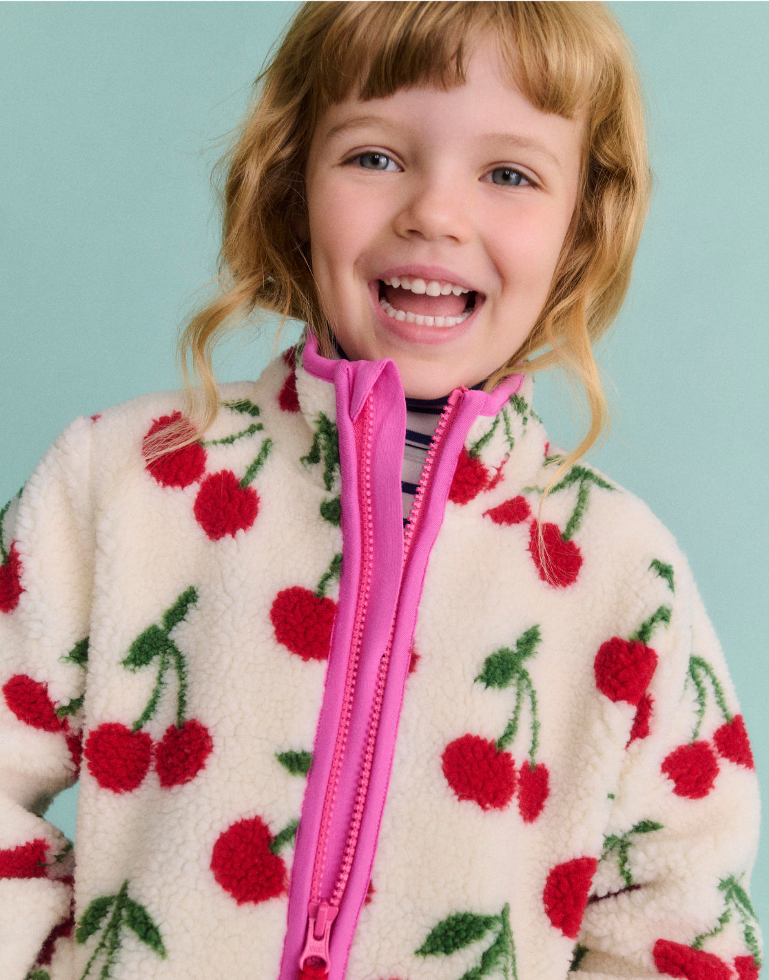 Girl wearing a Boden Jacket with cherries print