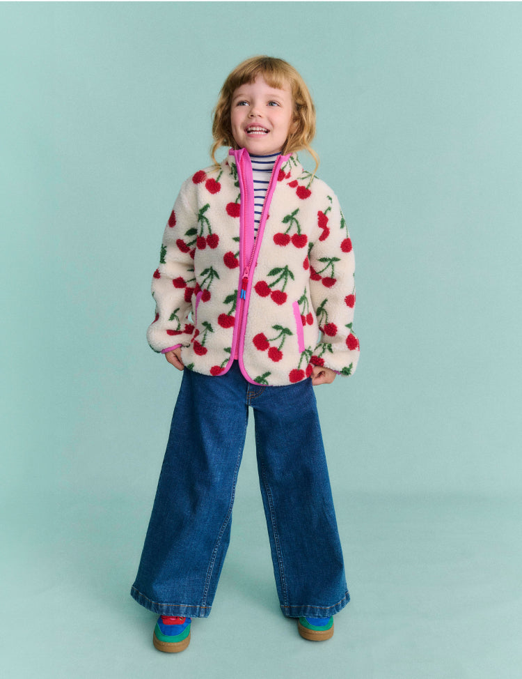 Girl wearing a Boden Jacket with cherries print