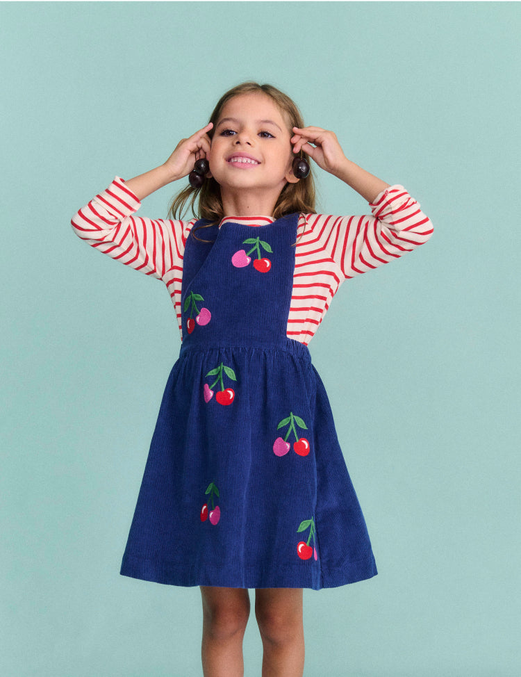 Girl wearing a Boden dress with Cherries print