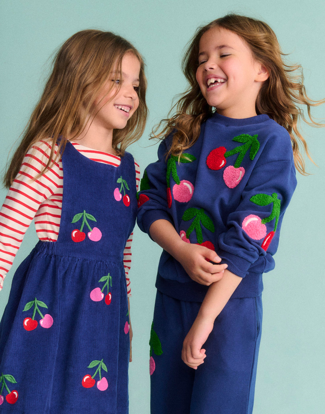 Girl wearing a Boden dress with Cherries print