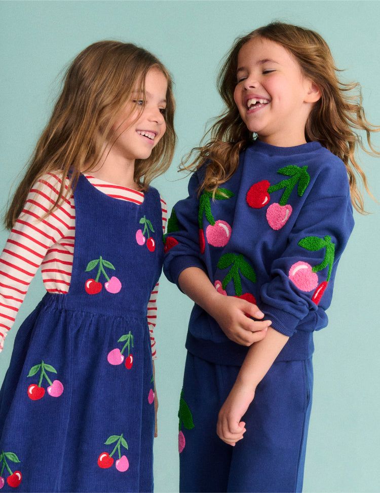 Girl wearing a Boden dress with Cherries print