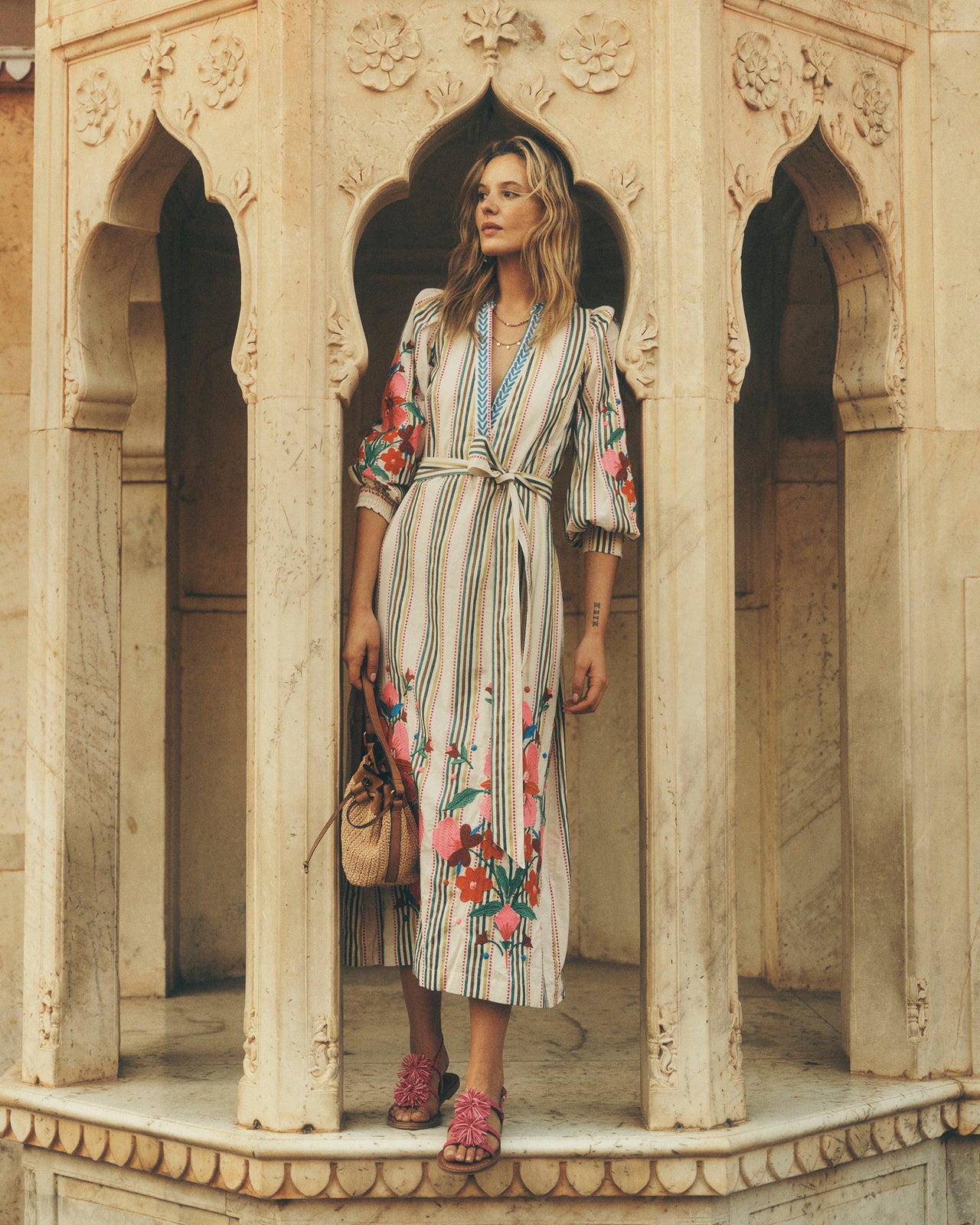 Woman in a floral dress standing in an ornate architectural setting
