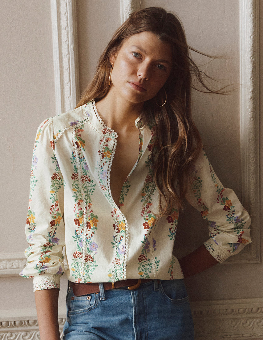 Woman wearing a floral blouse with a neutral background