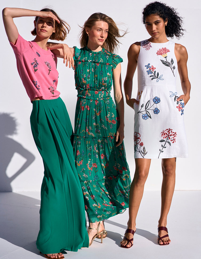 Three women wearing floral dresses on a white background