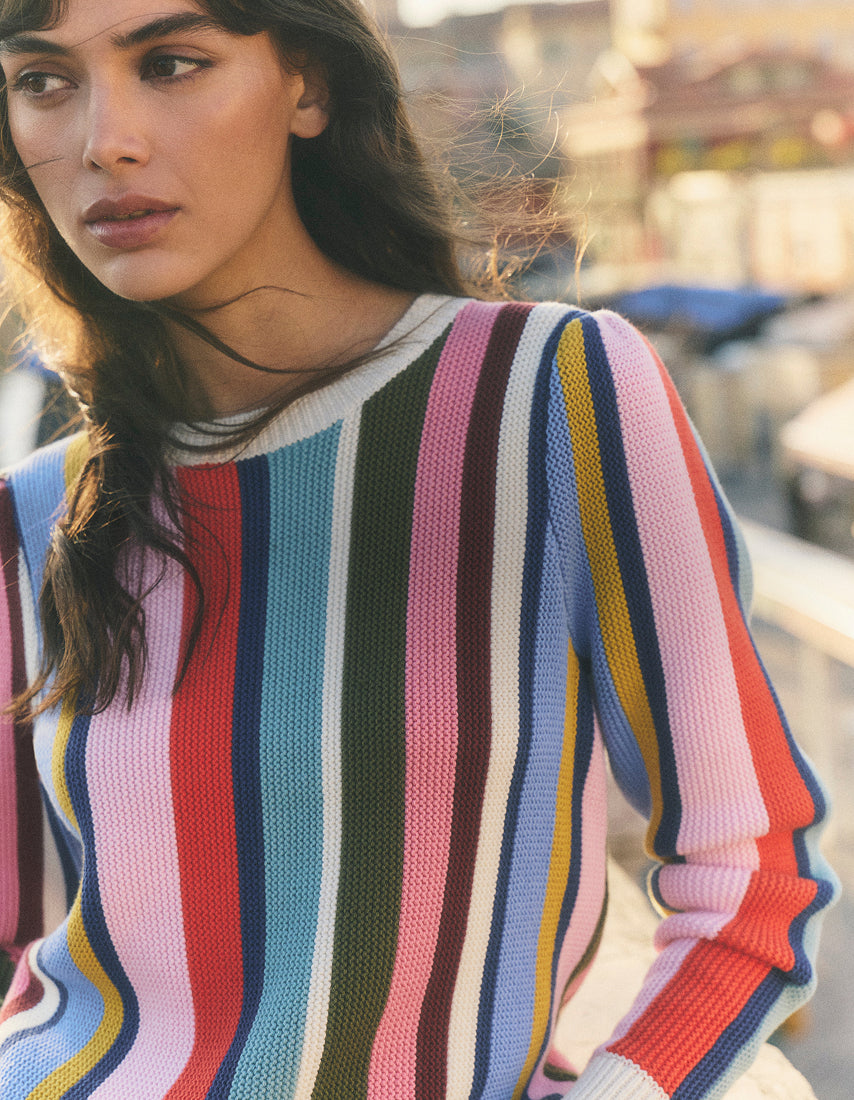 Woman wearing a colorful striped sweater with a blurred background