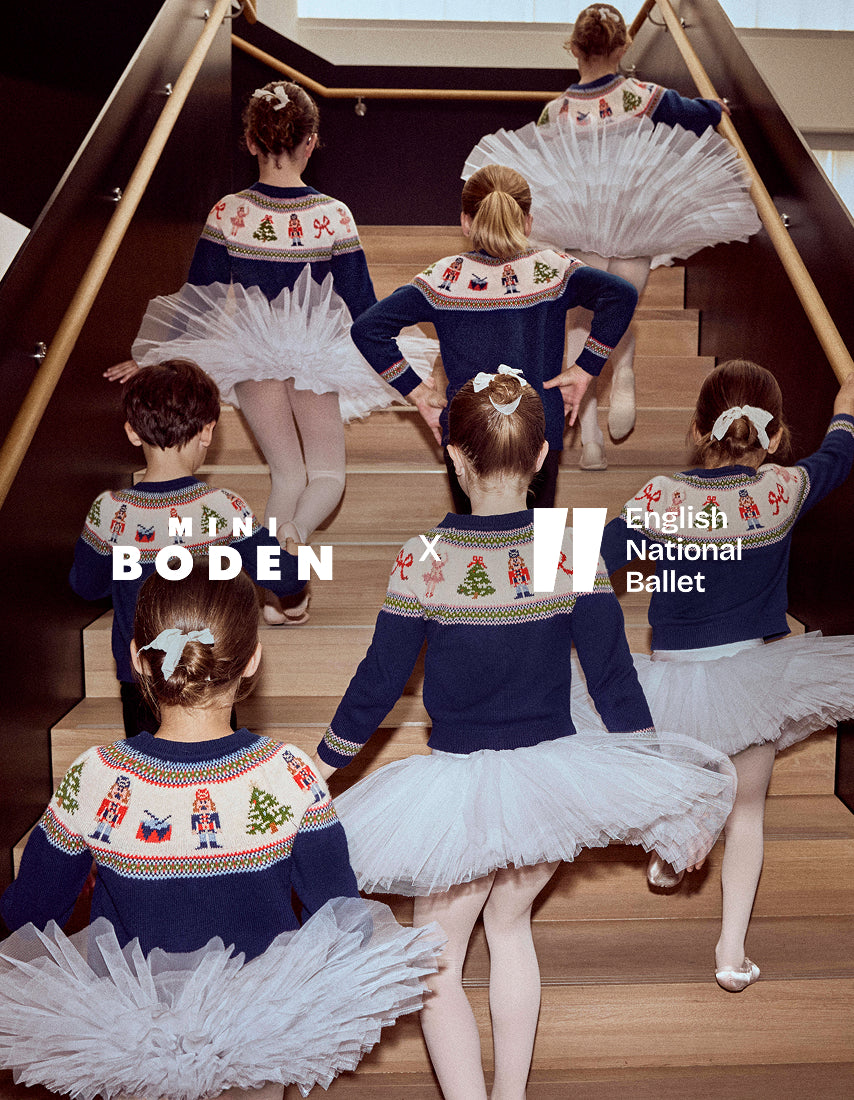Ballet dancers in matching outfits on a staircase with 'Boden' and 'English National Ballet' branding.