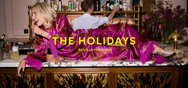Two people in vibrant purple robes sitting at a bar with 'The Holidays with Lucy Williams' text overlay.