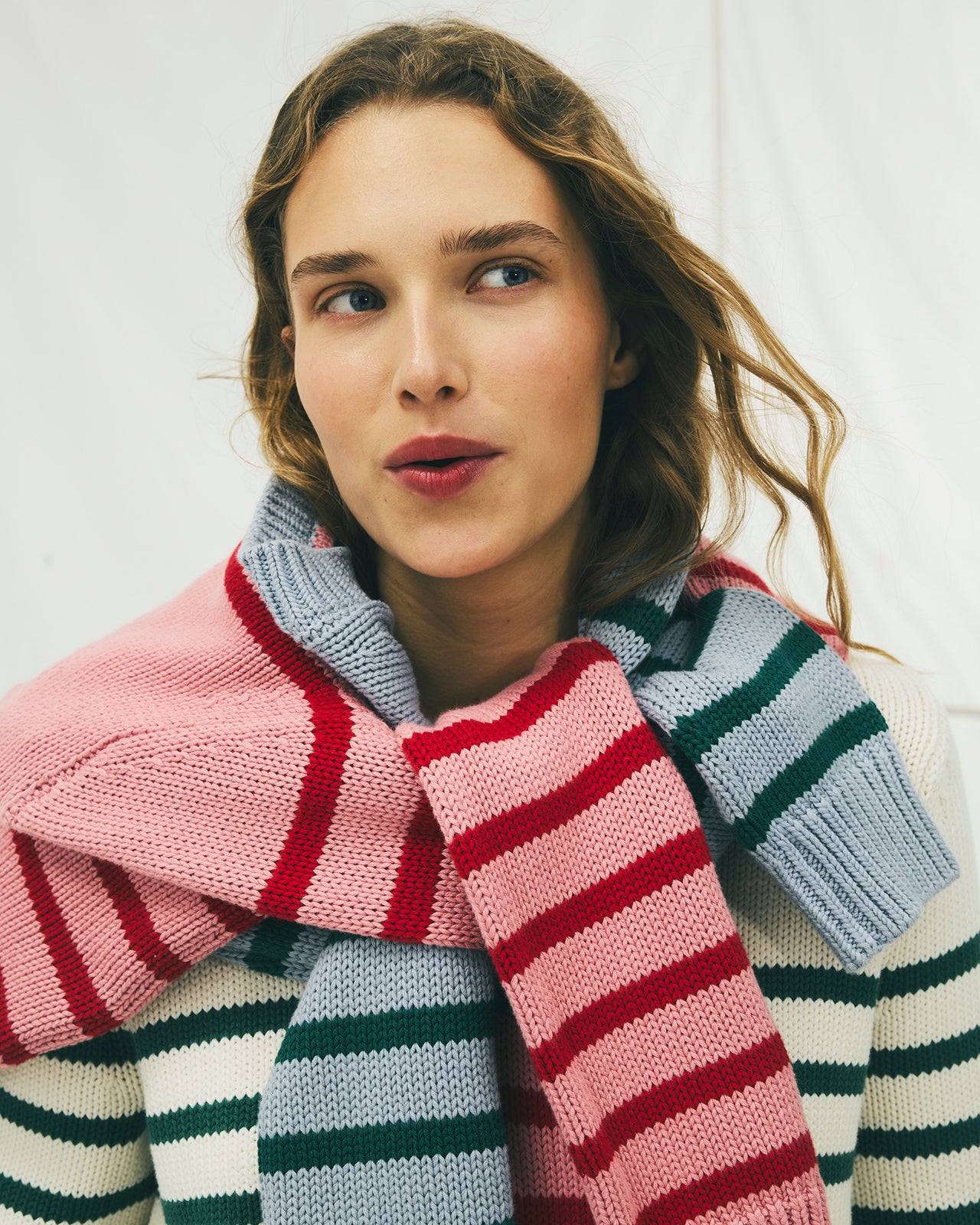 Woman wearing a colorful striped scarf against a white background