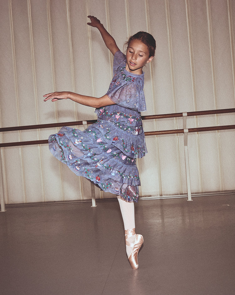 Dancer in a floral ballet outfit practicing in a studio.