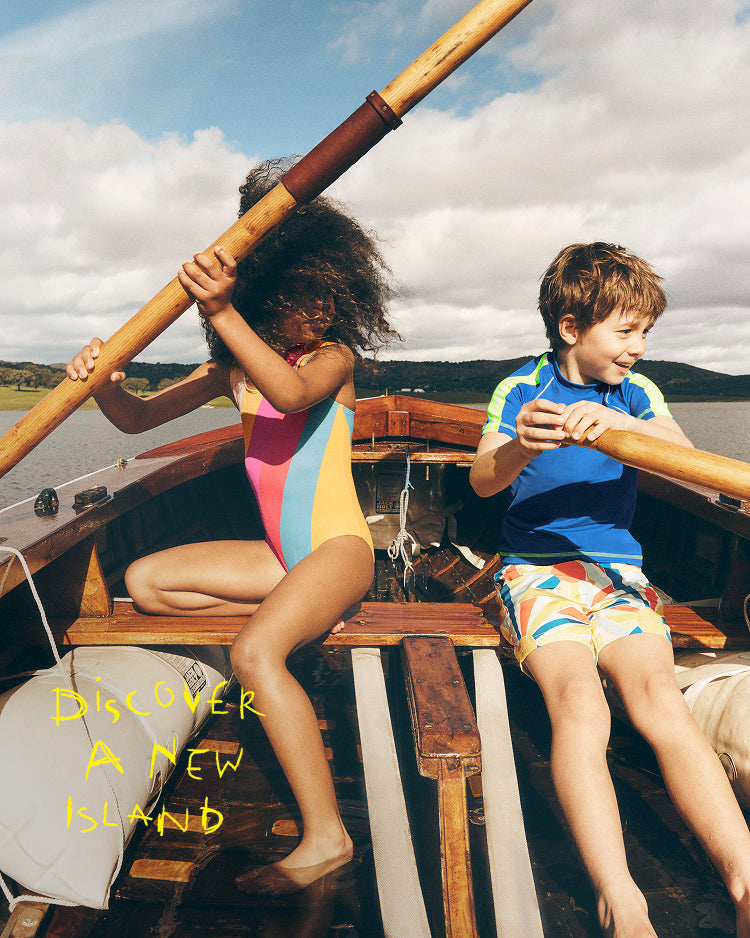 Two children on a boat with text 'Discover A New Island' on a scenic background.