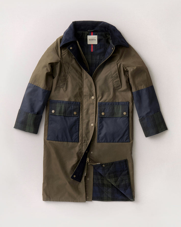 Green and navy coat with a visible brand label on a white background