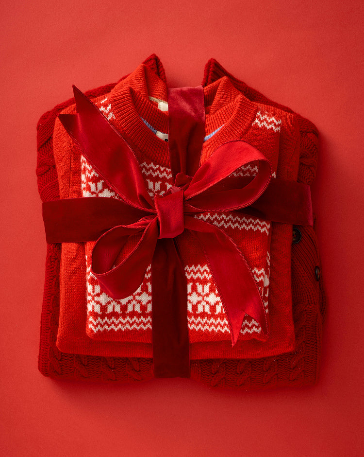 Red sweater with a decorative bow on a red background