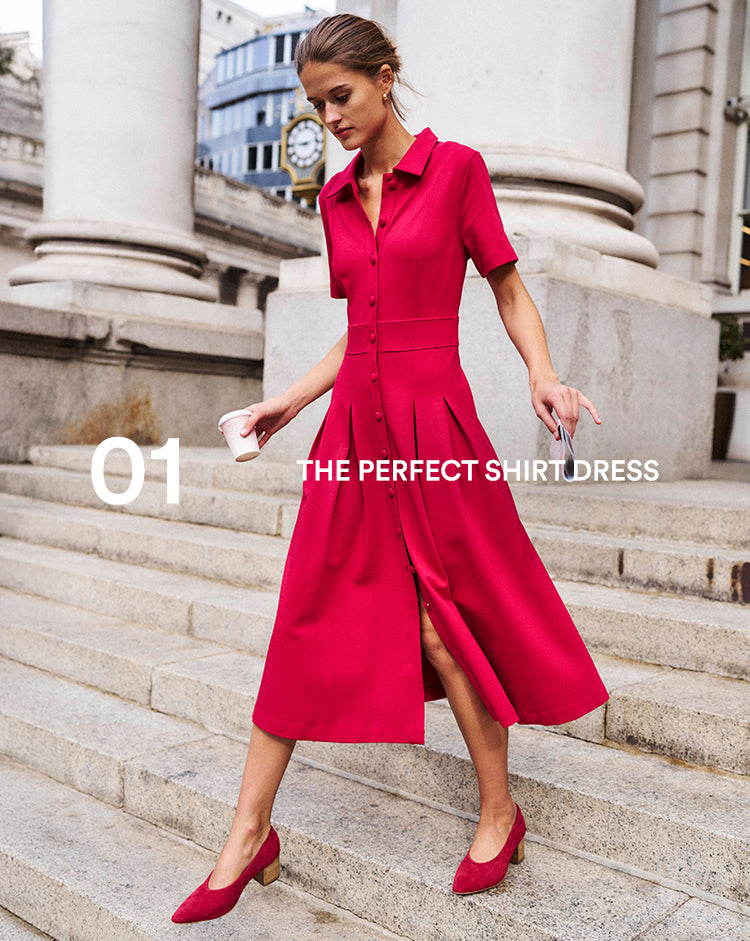 Woman in a red dress standing on stone steps with classical architecture in the background