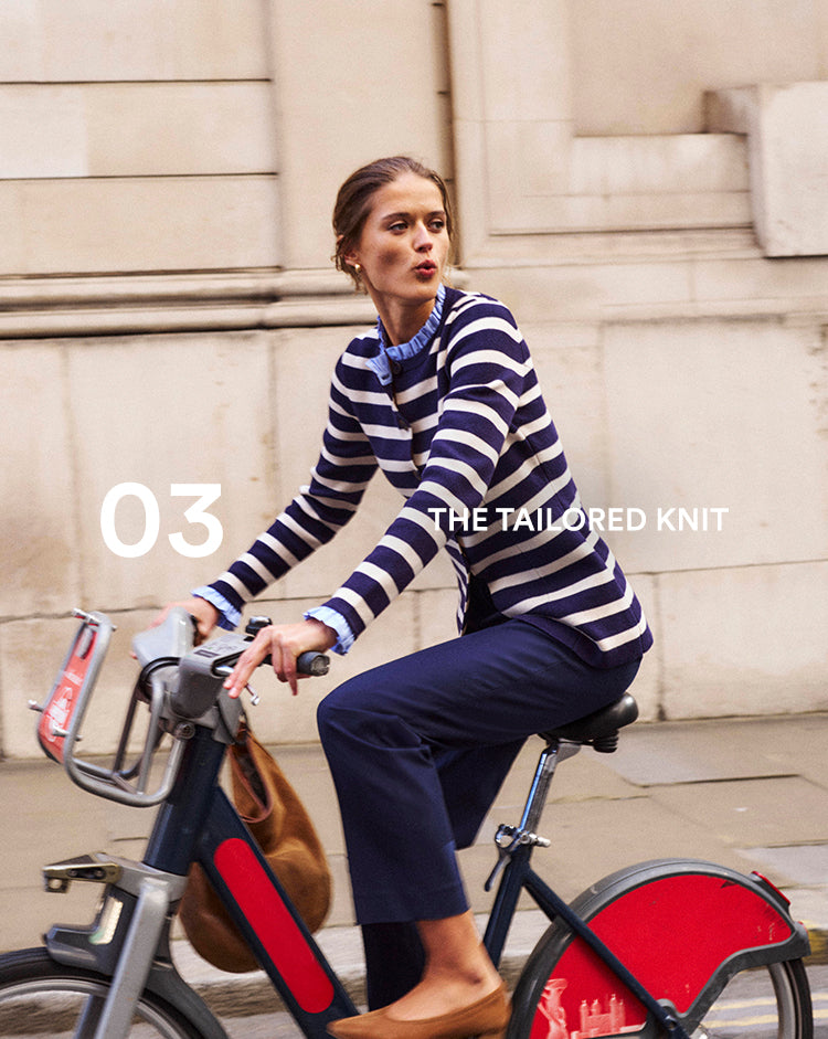 Woman in a striped sweater riding a bike with text 'The Tailored Knit' on a city street.