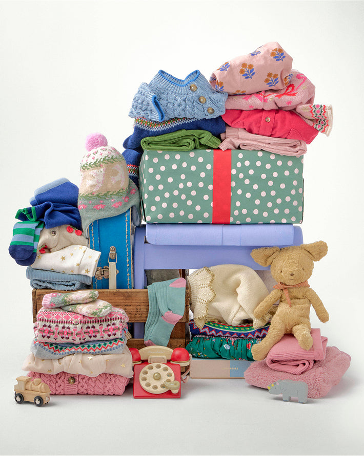 Stack of children's clothes and toys on a white background